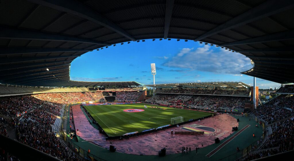 A lively crowd enjoys a football match at King Baudouin Stadium in Brussels.